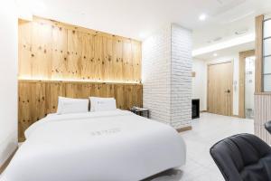 a bedroom with a white bed and wooden walls at Pandora Hotel in Hwaseong +55 photos