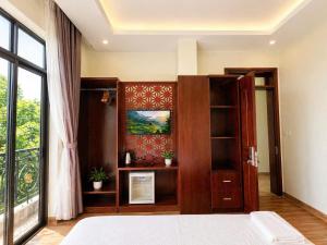 a bedroom with a bed and a large window at An Velora Boutique Hotel in Lai Nghê (2)