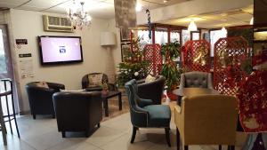 a waiting room with chairs and a tv in a store at Hôtel Eclipse in Magnanville