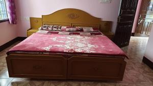 a bedroom with a large bed with a red comforter at Silver holidays in Yercaud