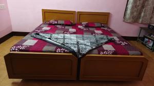 a bed with a quilt with a baseball bat on it at Silver holidays in Yercaud +1 photo