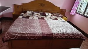a bed with a brown and white comforter in a bedroom at Silver holidays in Yercaud