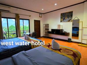 a hotel room with two beds and a balcony at west water hostel in Ban Khouaphan