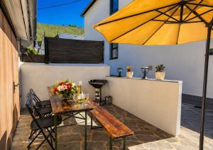a wooden table with an umbrella on a patio at Ferienwohnung an der Dhron in Neumagen-Dhron