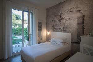 a bedroom with a bed with a painting on the wall at Arli Hotel Hideaway Punta Ala - Adults Only in Punta Ala +37 photos