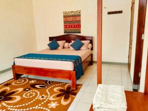 a bedroom with a bed with blue pillows on it at Homestay Possere in Sadang +9 photos