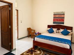 a bedroom with a bed with blue pillows at Homestay Possere in Sadang