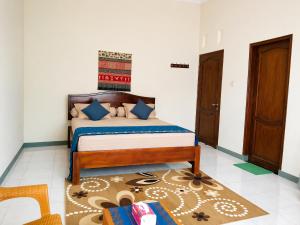 a bedroom with a bed with blue pillows at Homestay Possere in Sadang