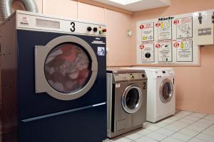 a laundry room with a washing machine and a dryer at Séjours & Affaires Orléans Jeanne D'Arc in Orléans