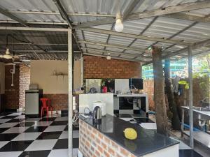 a kitchen with a counter in a room with a checkered floor at Nomad Guesthouse by Buntha in Phumĭ Réach Born (2)