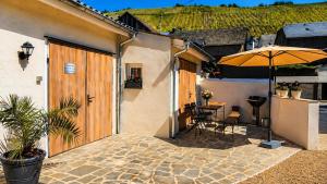a patio with an umbrella and a table and chairs at Ferienwohnung an der Dhron in Neumagen-Dhron +11 photos