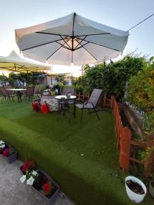 a patio with an umbrella and a table and chairs at Jennys Vintage Studio - Motorcycle Friendly in Drama