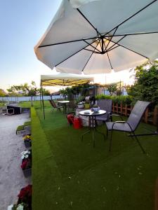 a table and chairs with an umbrella on the grass at Jennys Vintage Studio - Motorcycle Friendly in Drama