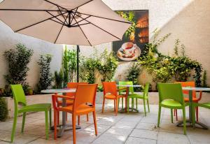 a group of tables and chairs with an umbrella at City Life Port Hotel in Heraklio