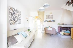 a white living room with a white couch and a table at Villa Anna in Torre Santa Sabina