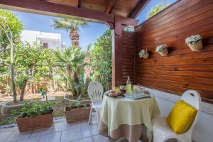 a table and chairs on a patio with palm trees at Villa Anna in Torre Santa Sabina