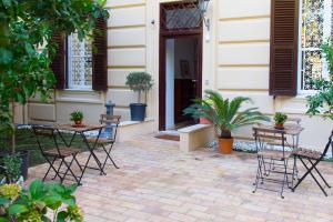 un patio con tavoli e sedie di fronte a un edificio di B&B Domus Aurea a Roma