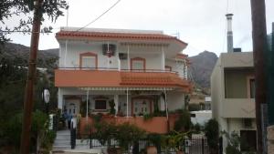 a large white house with a balcony on a street at Xenos Apartments in Keratokampos
