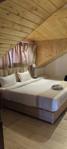 a bedroom with a large bed with a wooden ceiling at Katson Blue Dalhousie in Dalhousie