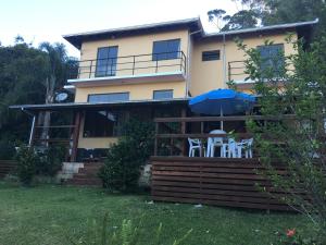 a house with two chairs and an umbrella at Morada Colibri in Gamboa