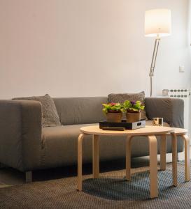 a living room with a couch and a coffee table at Homz Studios Faliro in Athens