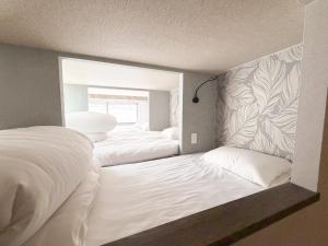 a bedroom with two beds and a window at ピンポンホテル Peace Park in Hiroshima