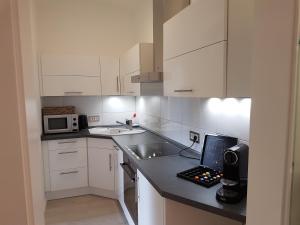 a kitchen with white cabinets and a laptop on a counter at Business Apartment Briller Viertel in Wuppertal