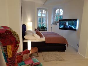 a bedroom with a bed with a tv on the wall at Business Apartment Briller Viertel in Wuppertal