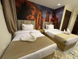 two beds in a room with stuffed animals on them at Rehana Pyramids View in Cairo