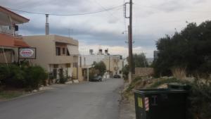 an empty street with a trash can on the side at Xenos Apartments in Keratokampos