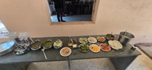 a bunch of bowls of food on a counter at Hotel Saffron Indian Spice Resort in Chitrāwal