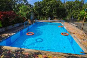 a large swimming pool with orange tubes in it at Hotel Saffron Indian Spice Resort in Chitrāwal