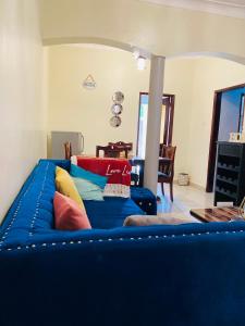 a blue couch with pillows on it in a living room at Private Home in Bugiri