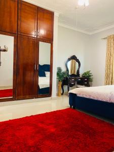 a bedroom with a bed and a large red rug at Private Home in Bugiri