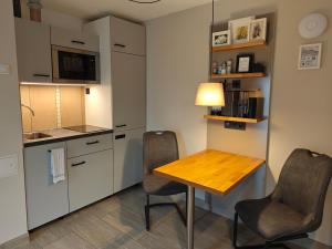 a small kitchen with a wooden table and two chairs at Apartment Maiglöckchen in Fritzlar