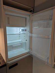 an empty refrigerator with its door open in a kitchen at Apartment Maiglöckchen in Fritzlar +18 photos