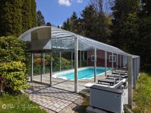 a glass pavilion with a swimming pool in it at Pension Irlingerhof in Mondsee