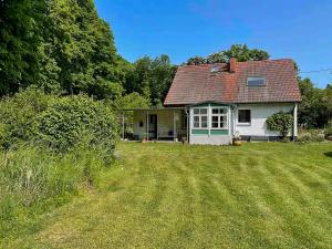 a small white house with a grass yard at House Between Forest And Fields In Brandenburg in Casekow