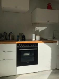 a kitchen with a black oven and white cabinets at House Between Forest And Fields In Brandenburg in Casekow