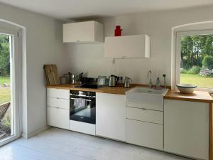 a kitchen with white cabinets and a sink at House Between Forest And Fields In Brandenburg in Casekow