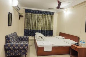 a hospital room with a bed and a chair at Aanand Hotel in Janakpur