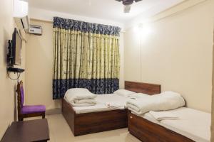 a room with two beds and a window at Aanand Hotel in Janakpur
