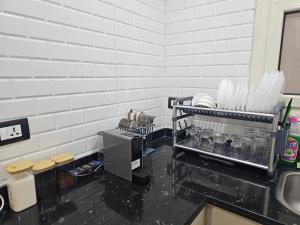 a kitchen with a sink and a counter with dishes at Salalah Apartment in Cairo