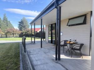 a patio with a table and chairs on a house at Guesthouse on Ostler in Twizel