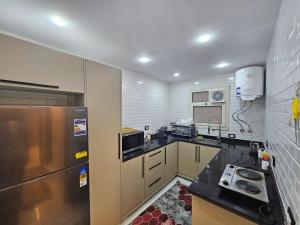 a kitchen with a stainless steel refrigerator and cabinets at Salalah Apartment in Cairo