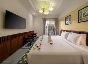 a hotel room with a bed with a flat screen tv at Solea Boutique Hoi An - Grand Opening April 2026 in Hoi An