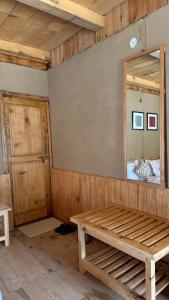 a room with a mirror and a wooden bench at SAANJH, Shangarh in Shangarh