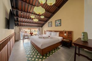 a bedroom with a bed and a dining room at Solea Boutique Hoi An - Grand Opening April 2026 in Hoi An +36 photos
