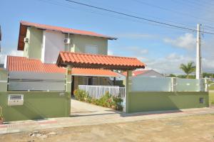 una casa con techo naranja y una valla blanca en Pousada Mar de Almirante, en Penha