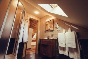 a bathroom with a shower and a sink with towels at Denisa Boutique in Poiana Brasov